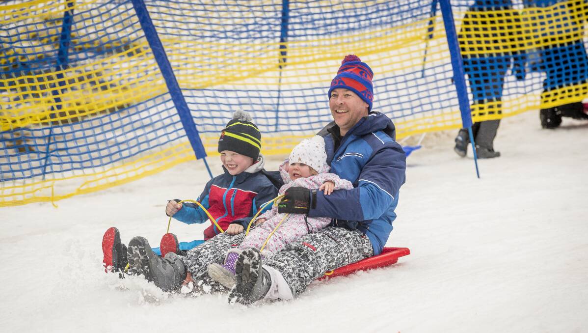 Oliver, 6, Annabelle, 2, and Matthew Carmody, from Duffy, tobogganing at Corin Forest. Picture: Sitthixay Ditthavong