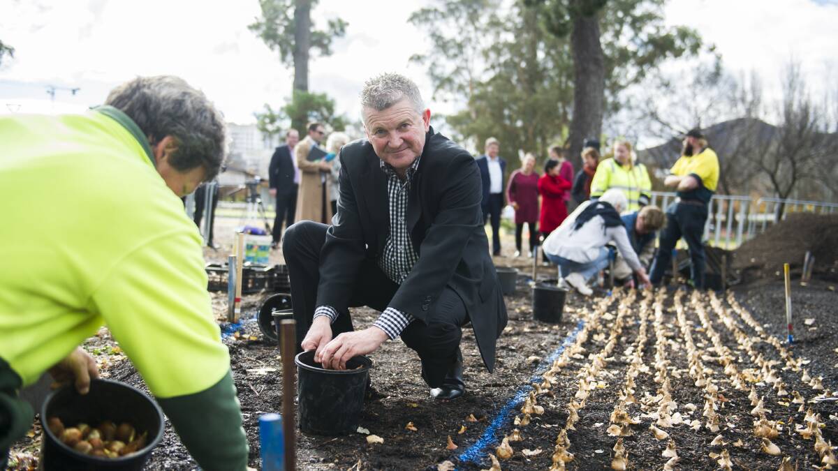 Floriade head gardener Andrew Forster, left, and senior director of the National Arboretum Canberra Scott Saddler, centre, helping plant the new Indigenous Australia flowerbed. Picture: Dion Georgopoulos