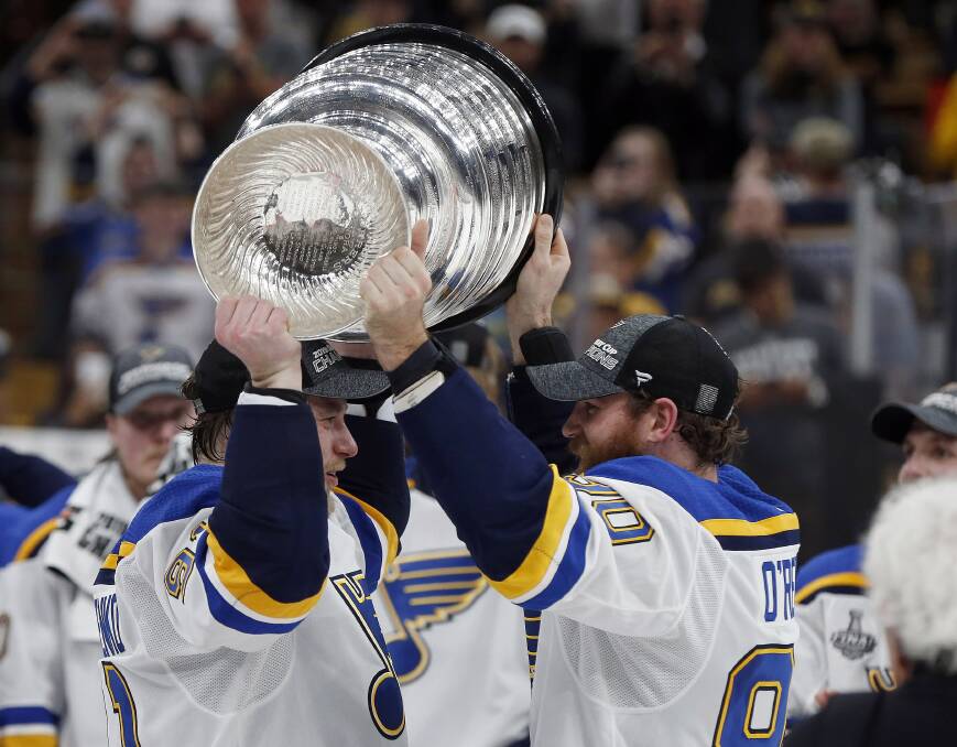 St. Louis Blues' Ryan O'Reilly, right, hands the Stanley Cup to Vladimir Tarasenko, left. Picture: AP