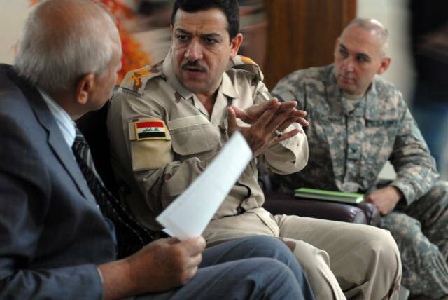 Sameer Alazraqi in his military uniform speaking with the Iraqi Medical Syndicate president and an American medical officer in Baghdad in 2009. Picture: Supplied