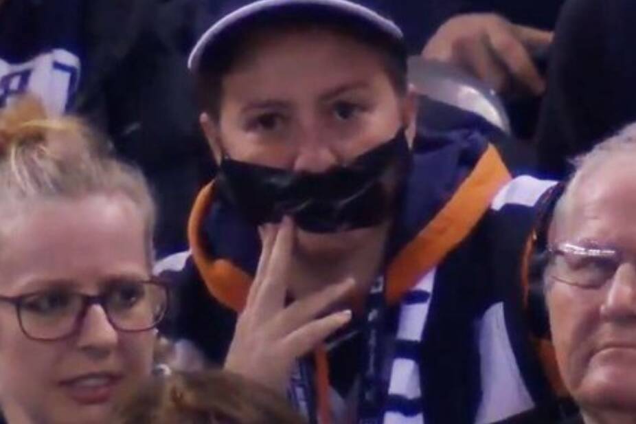 A Carlton fan wears tape over her mouth to protest against the AFL's crowd behaviour measures. Picture: Channel 7