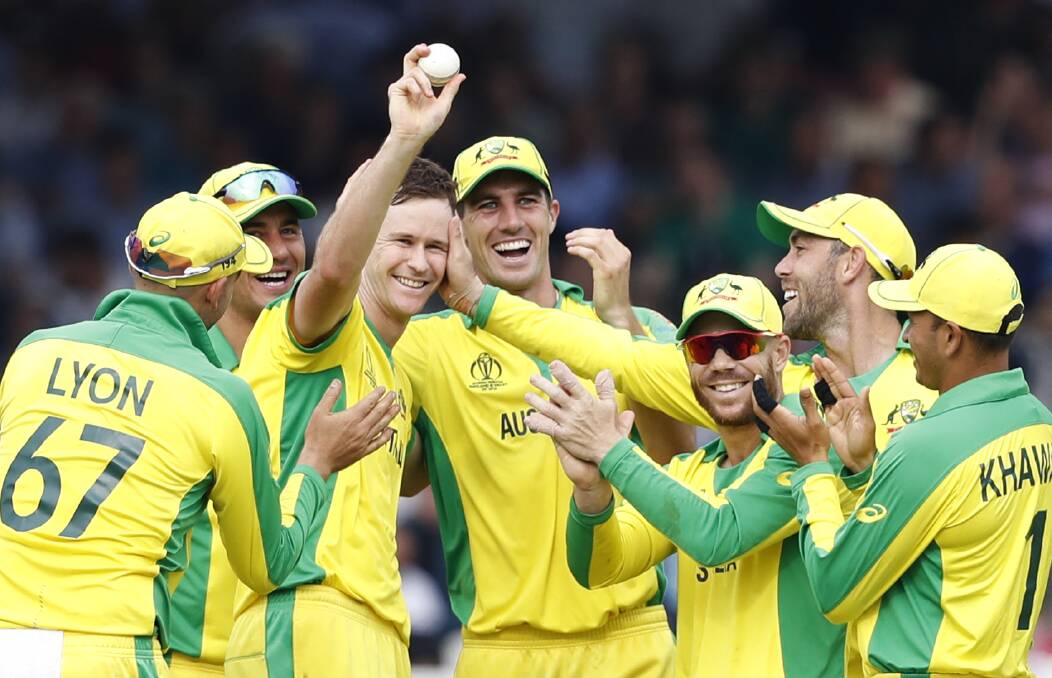 Australia's Jason Behrendorff, centre, holds up the ball as he celebrates with teammates after taking the wicket of England's Jofra Archer. Picture: AP Photo