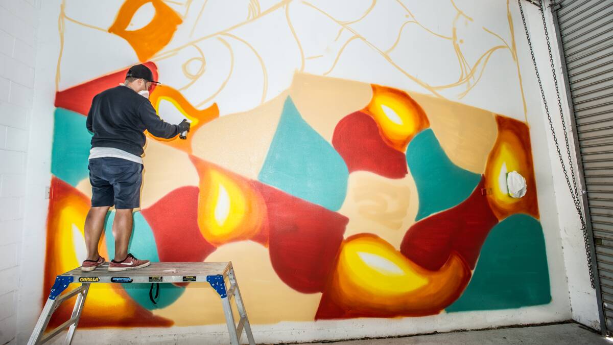 Artist PAW working on the mural. Picture: Karleen Minney