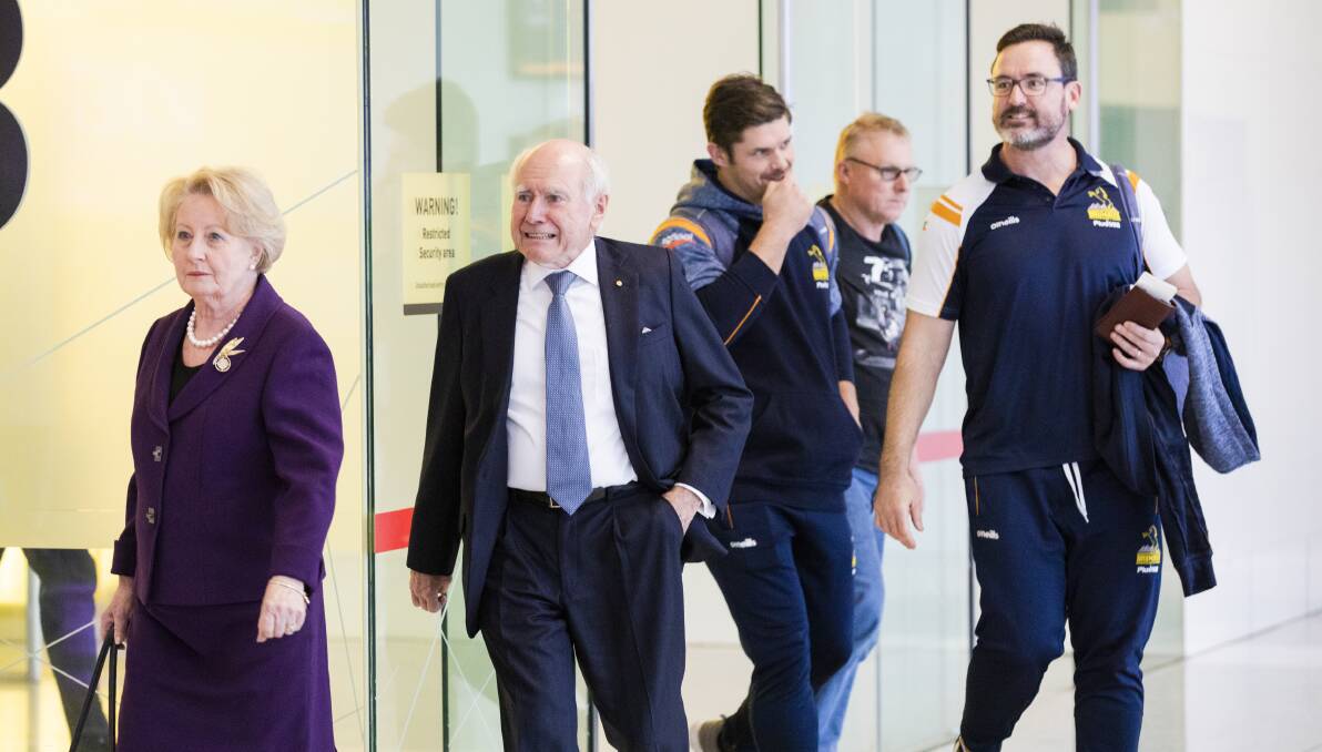 Brumbies coaches Dan McKellar, right, and Ruaidhri Murphy follow former prime minister John Howard and wife Janette into the airport arrivals. Picture: Jamila Toderas