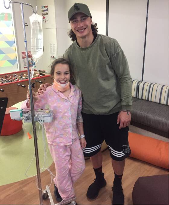 Charnze Nicoll-Klokstad visiting a fan in hospital this week. Picture: Michael Eugenio/Twitter
