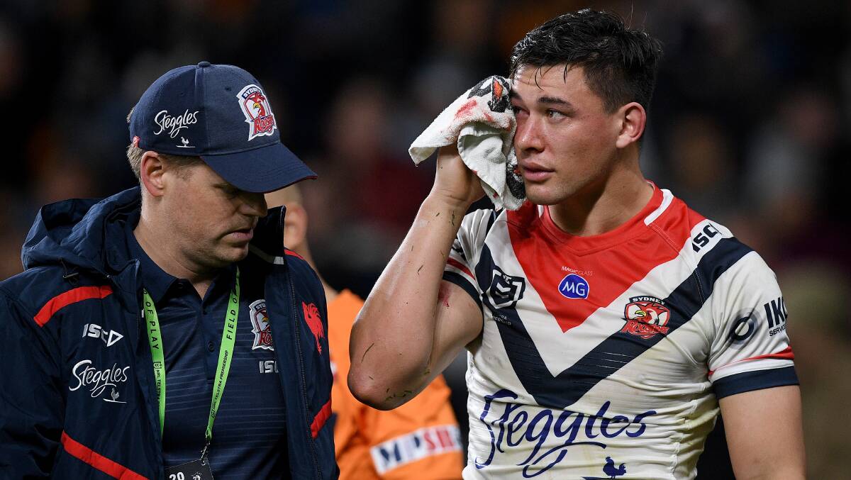 Joseph Manu of the Roosters receives attention for a head wound during round 16. Picture: AAP