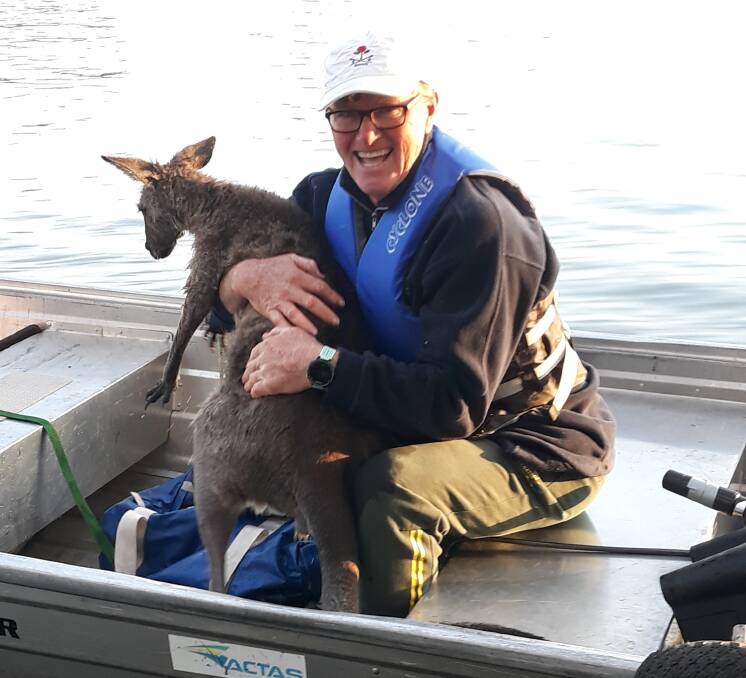 ACT Academy of Sport rowing coach Nick Garratt with a rescued kangaroo earlier this year. Picture: Supplied