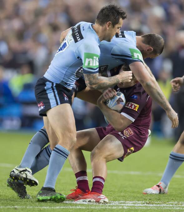 Cameron Munster of the Maroons is swamped by the NSW defence on Wednesday night. Photo: AAP