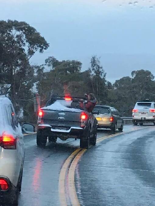 Police have shared this image of person hanging out of the window of a dark-coloured Ford utility on Kosciusko Road on Saturday, July 13, 2019. Picture: NSW Police