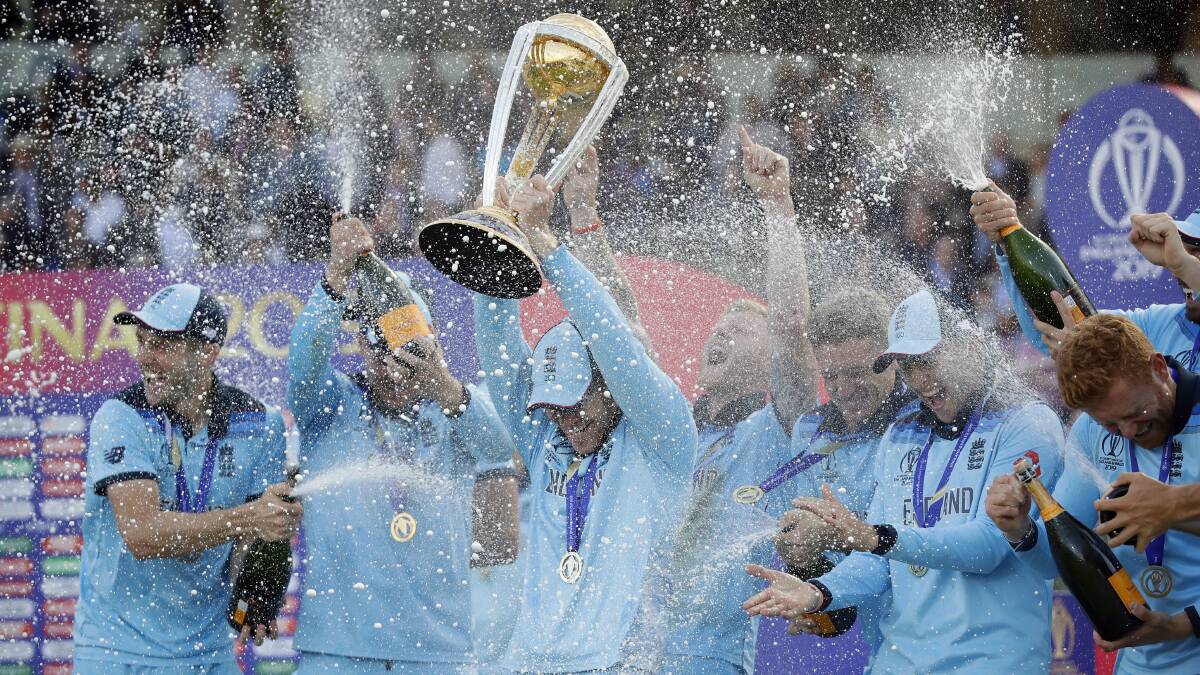 England's captain Eoin Morgan is doused in champagne as he raises the trophy. Picture: AP