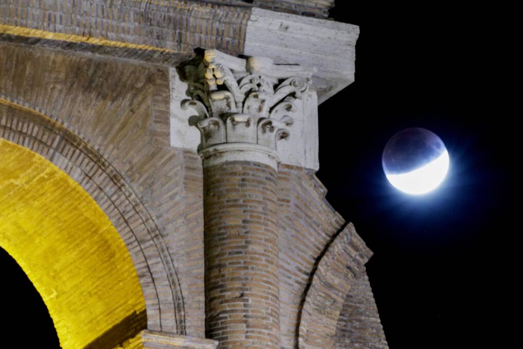 A rising full moon is seen over the Colosseum during a partial lunar eclipse in Rome on July 16. Picture: Andrew Medichini/AP Photo