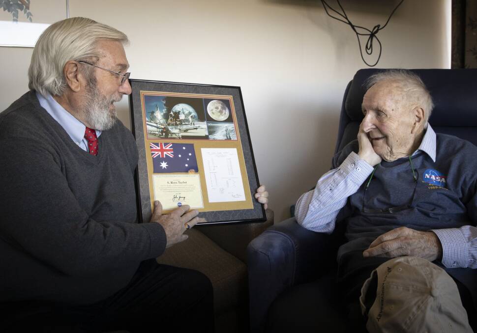 Former NASA scientist, Dr Everett Gibson (left) presents Professor Ross Taylor with official recognition for his 50 years of research. The plaque contains his results from fifty years ago and an Australian flag that has been to the moon. Picture: Sitthixay Ditthavong