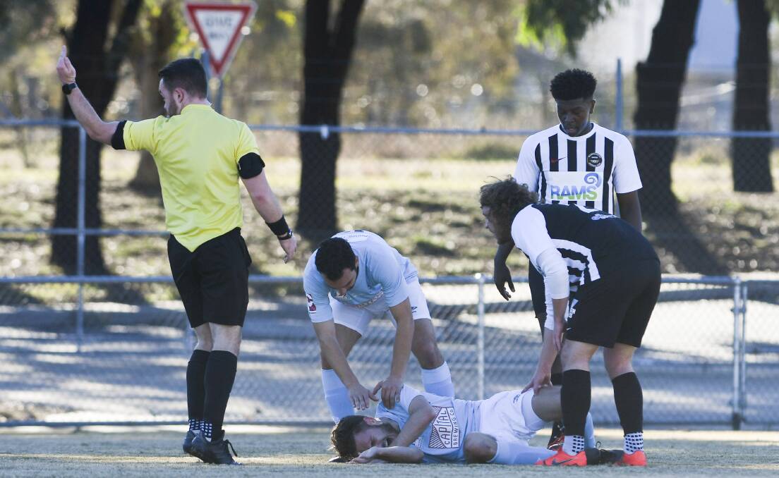  Belconnen's Christian Pratezina broke his leg in the first half on Saturday. Picture: Dion Georgopoulos