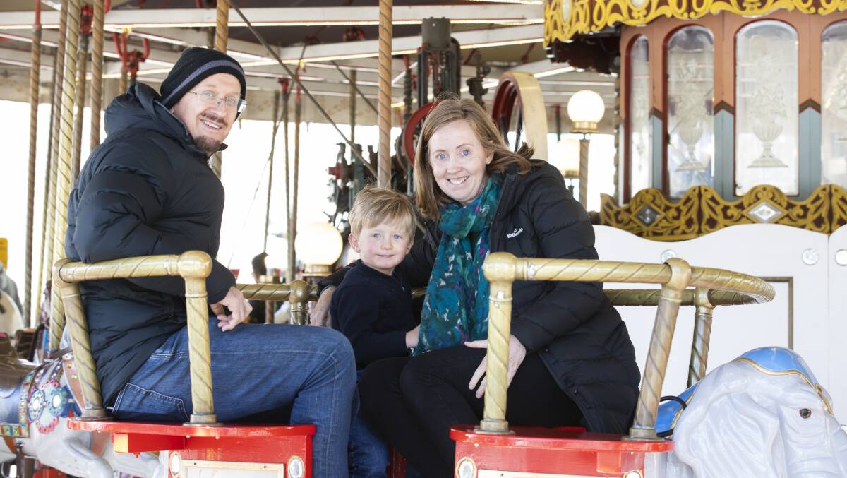 Alex, Dion, and Jodie Kouvaras from Queanbeyan, riding the Civic carousel on Sunday. Picture: Sitthixay Ditthavong