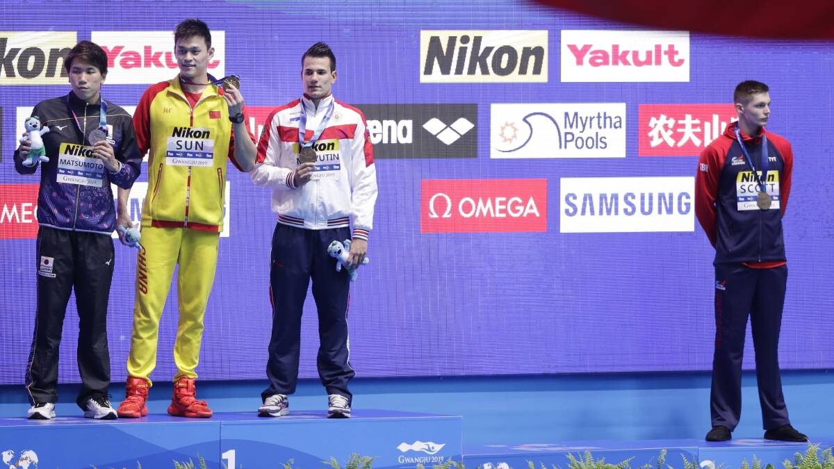Britain's bronze medalist Duncan Scott, right, refuses to stand with gold medalist China's Sun Yang, second left. Picture: AP