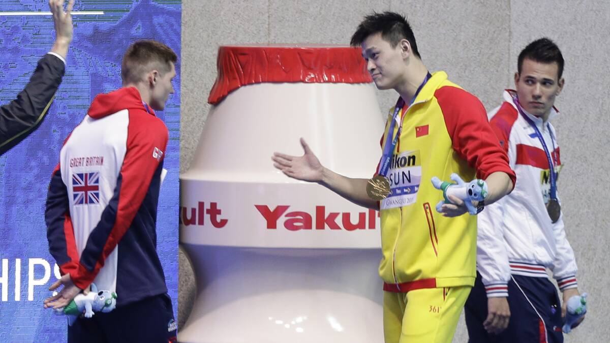 Gold medalist China's Sun Yang gestures to Britain's bronze medalist Duncan Scott, left, following the medal ceremony in the men's 200m freestyle final at the World Swimming Championships. Picture: AP