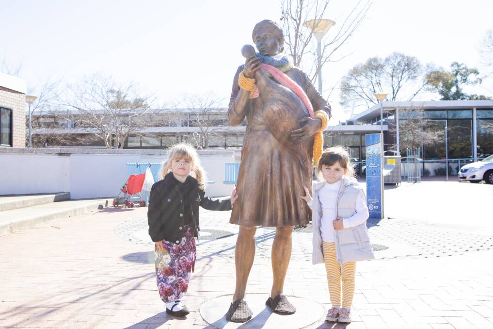 Two-year-olds Amelia Bright and Sophia Michael with the wrapped-up sculpture. Picture: Jamila Toderas