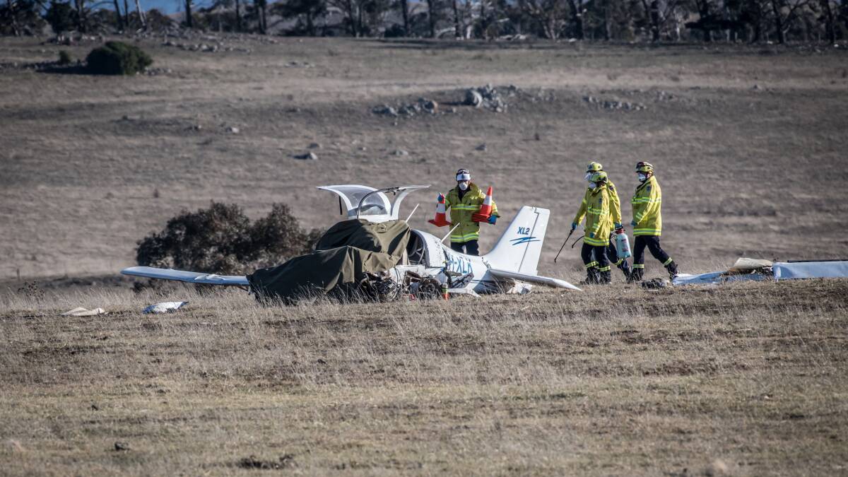 Firefighters inspect the wreckage of the plane. Picture: Karleen Minney
