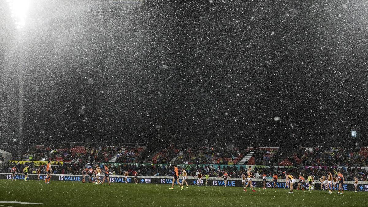 Snow falls on the ground during the game at Manuka Oval. Picture: Alex Ellinghausen