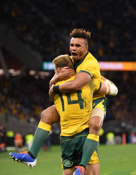 Wallabies player Will Genia (right) reacts with Reece Hodge after Hodge scored a try. Picture: AAP