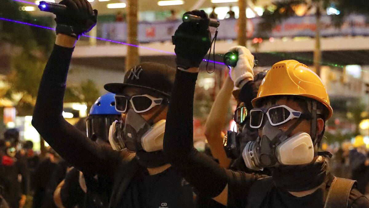 Protesters point lasers at police and facial recognition cameras. Picture: Vincent Thian, AP.