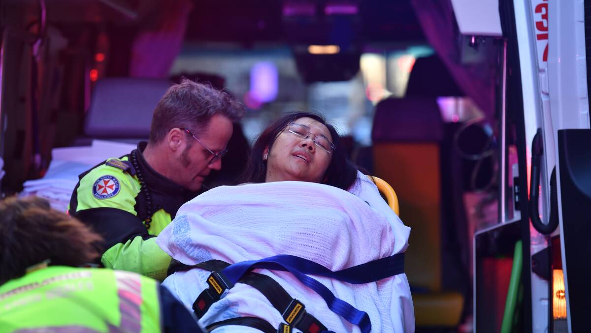 The woman who was stabbed outside Hotel CBD is taken away in an ambulance. Picture: AAP