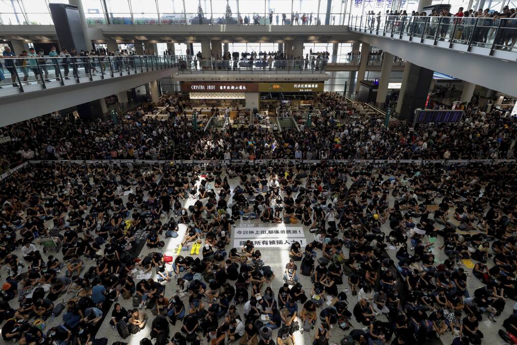 Protesters surround banners that read "Those on the street today are all warriors!" and "Release all the detainees!" during a sit-in rally at the arrival hall of the Hong Kong International Airport. Picture: AP