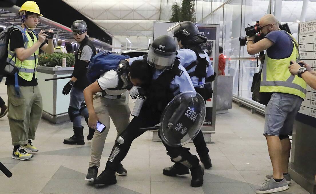 Policemen in riot gear arrest a protester in Hong Kong. Picture: AP