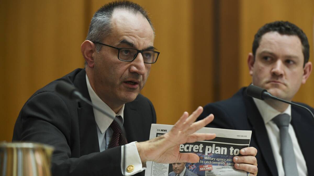 Home Affairs Department Secretary Mike Pezzullo holds up a copy of a newspaper during a hearing of the Parliamentary Joint Committee on Intelligence and Security at Parliament House on Wednesday. Picture: AAP