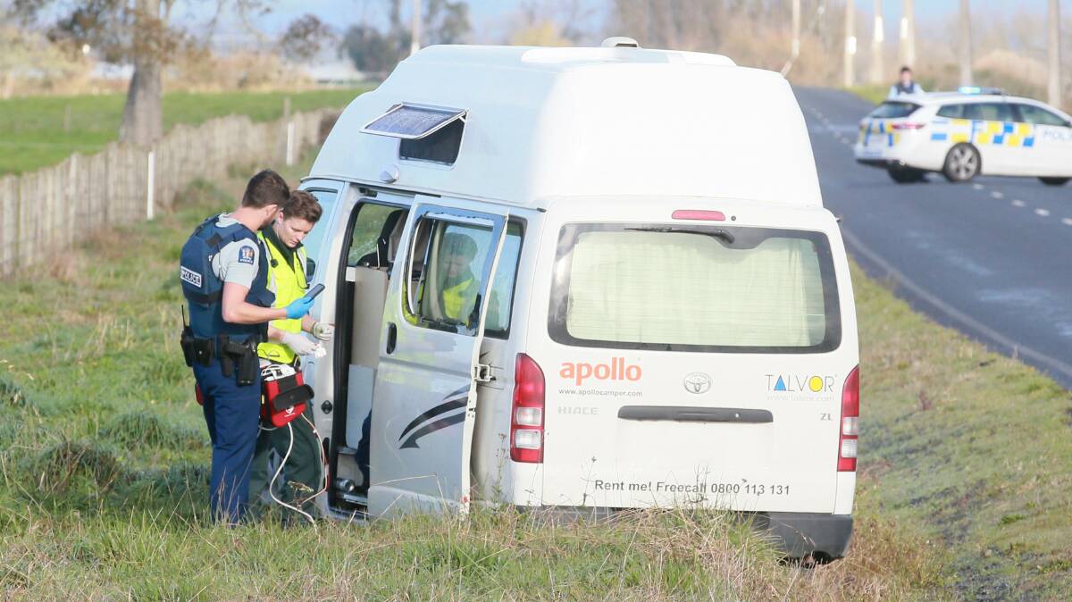 An officer and paramedic work through the open door of the campervan where the body of a man was found on Friday morning. Picture: Mark Taylor / Stuff.