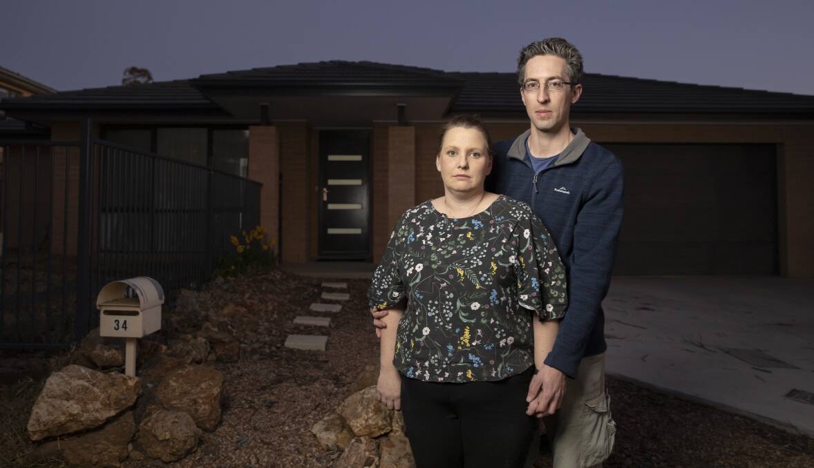 Christina and Chris Pilkington, who were part of the ACT government's voluntary buy-back scheme and rebuilt in Ainslie, out the front of their new home. Picture: Sitthixay Ditthavong