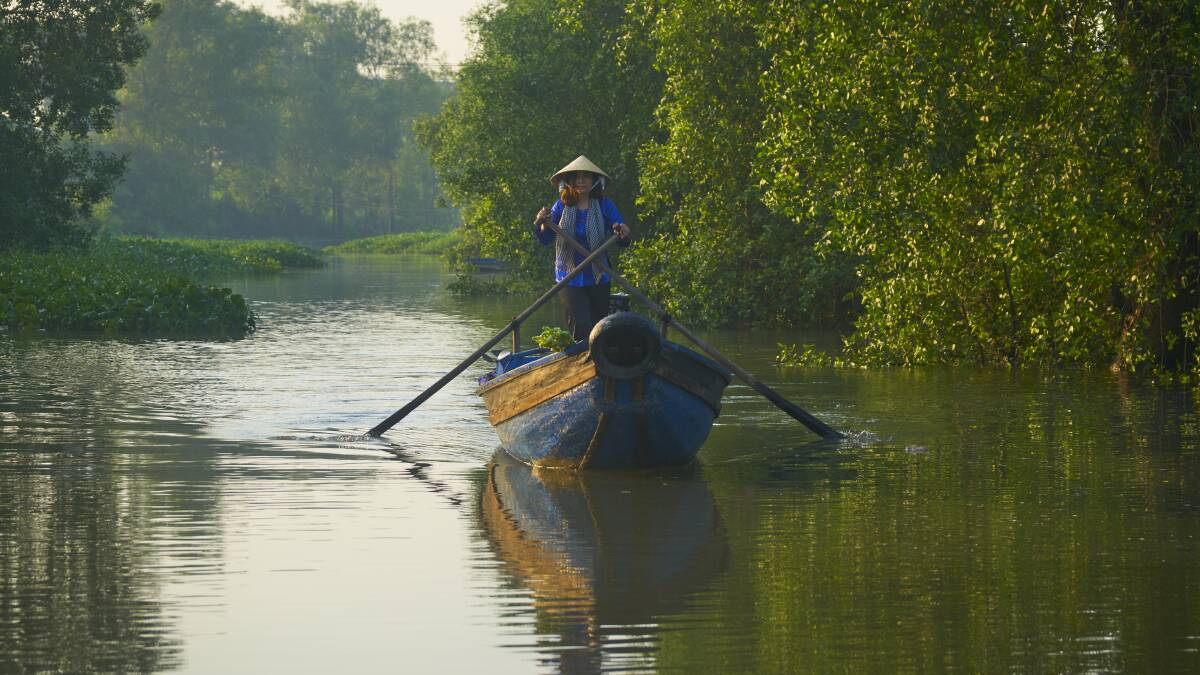 A woman travels down a river on a boat in Vietnam's Mekong Delta region, which is home to about 21.5 million people. Picture: Supplied