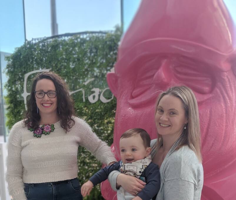 Winners of the gnome naming contest, Crystal Prior, of Kambah, and Jane Paddick, of Queanbeyan (with one-year-old Cameron), and Floyd the pink gnome. Picture: Megan Doherty