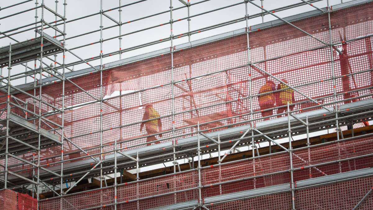 Inspectors examining a construction site on Friday, where a worker fell from scaffolding on DKSN building in Dickson. Picture: Elesa Kurtz