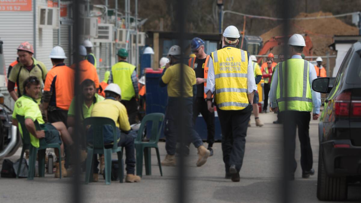 Workers on the DKSN construction site stop work after a man fell from scaffolding on Friday. Picture: Elesa Kurtz