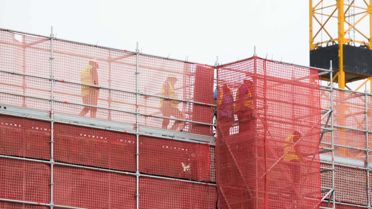 WorkSafe officials look at scaffolding at the construction site on Friday after a man fell and was taken to hospital in a critical condition. Picture: Elesa Kurtz