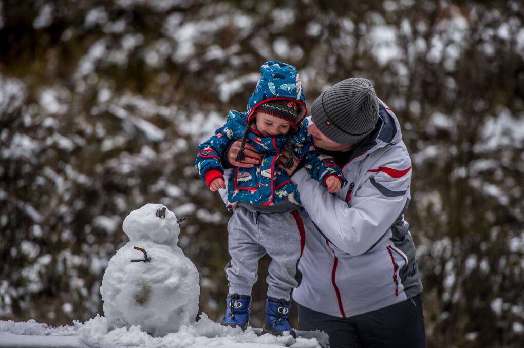 Bruce Lauer, 2, of Red Hill experiences snow for the first time with father Ben at Corin Forest. Picture: Karleen Minney