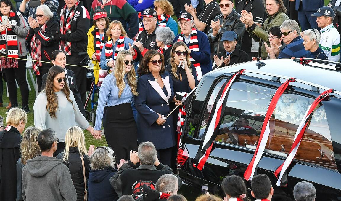 Danny Frawley's wife and daughters walk behind his hearse at Moorabbin Oval. Picture: Joe Armao