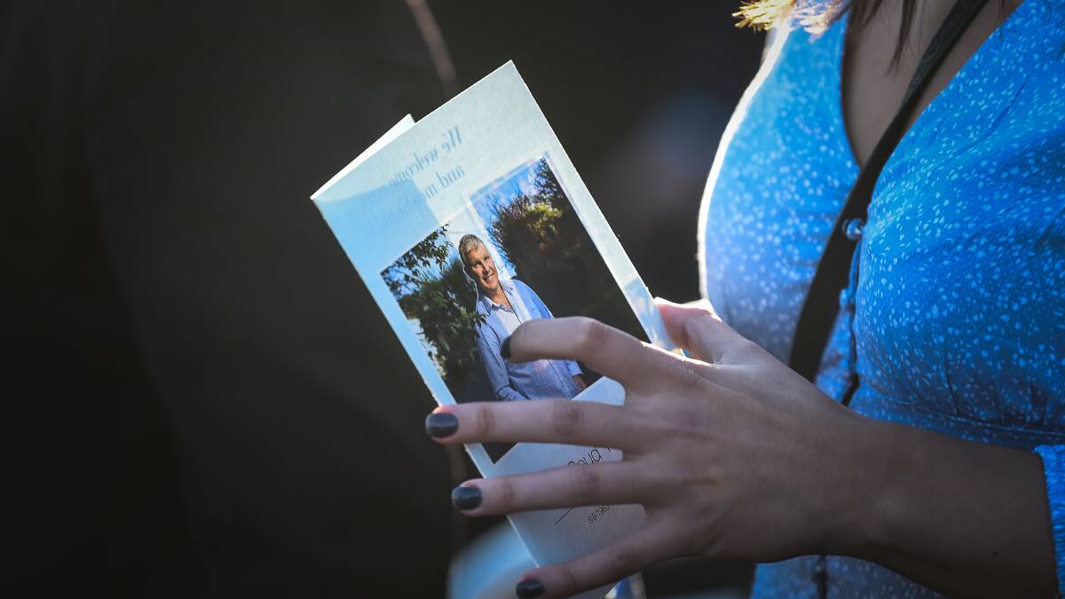 A woman holds the order of service booklet at Fraw;ey's public funeral. Picture: Justin McManus