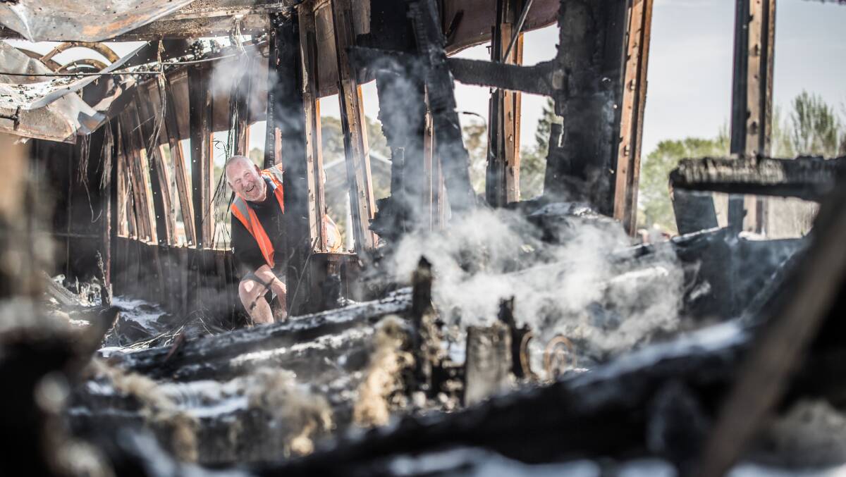 Volunteer Glenn Bridgart inspects one of the railway carriages that was set alight at the Canberra Railway Museum in Kingston the morning of its grand re-opening. Picture: Karleen Minney