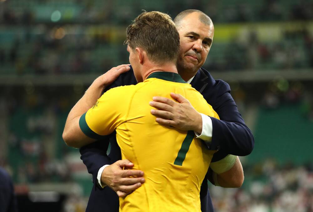 Michael Cheika embraces Wallabies captain Michael Hooper after Saturday night's quarter-final loss against England in Japan. Picture: Getty Images