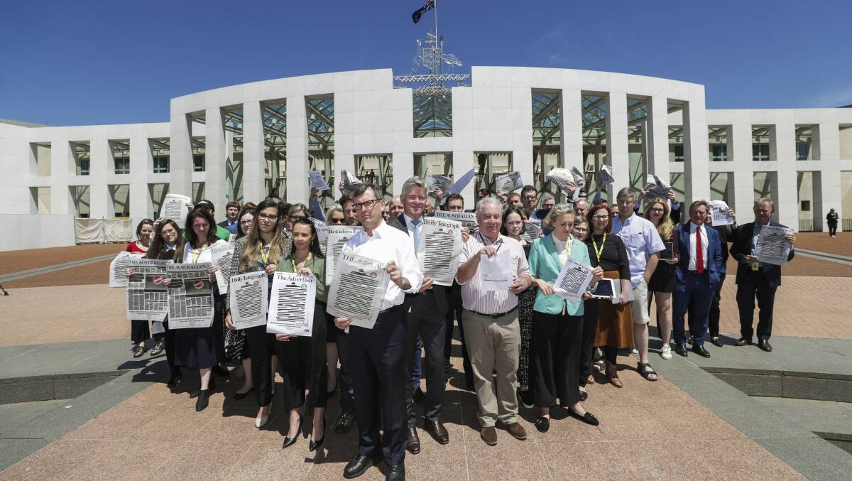 David Crowe, president of the Federal Parliamentary Press Gallery and members of the press gallery hold up redacted copies of Monday's front pages supporting the Your Right to Know campaign. Picture: Alex Ellinghausen