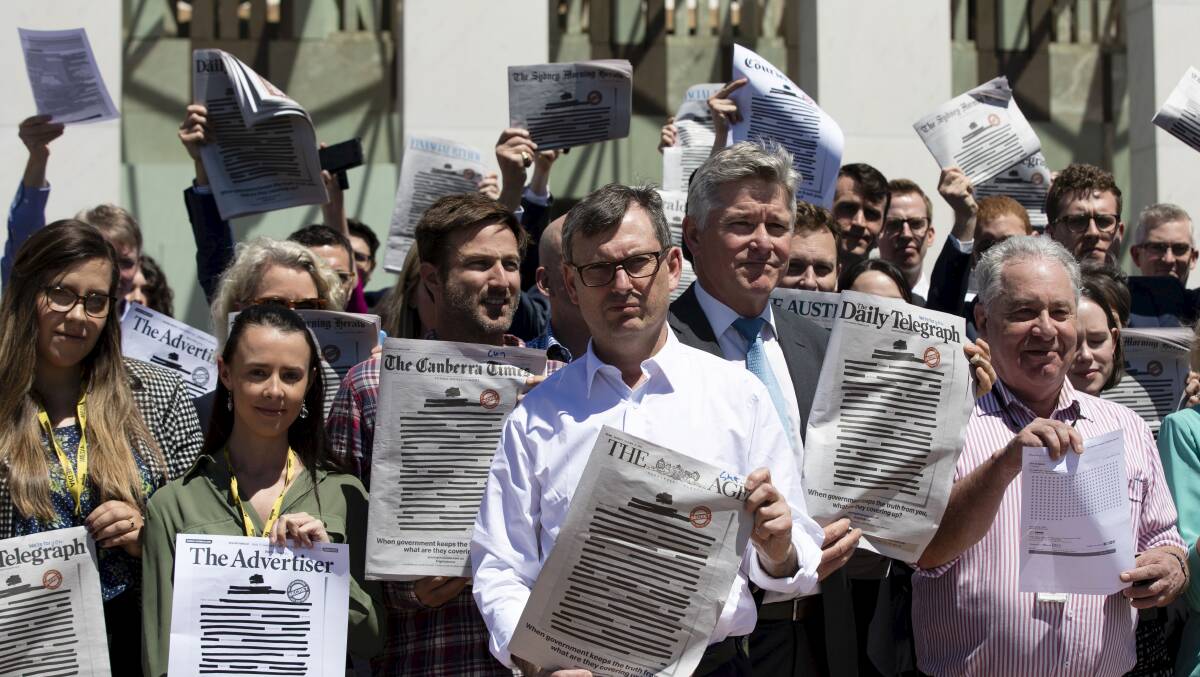 Journalists and photojournalist from the Federal Parliamentary Press Gallery show the covers of Australias newspapers with redacted front pages. Picture: Dominic Lorrimer