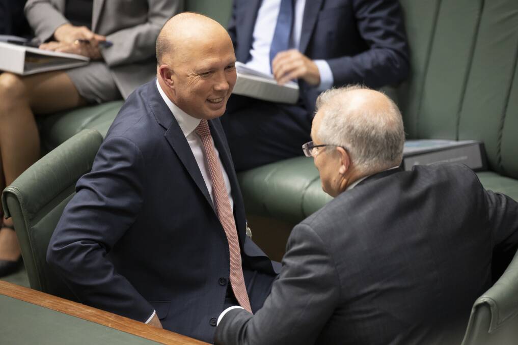 Minister for Home Affairs Peter Dutton chats with Prime Minister Scott Morrison during question time. Picture: Sitthixay Ditthavong