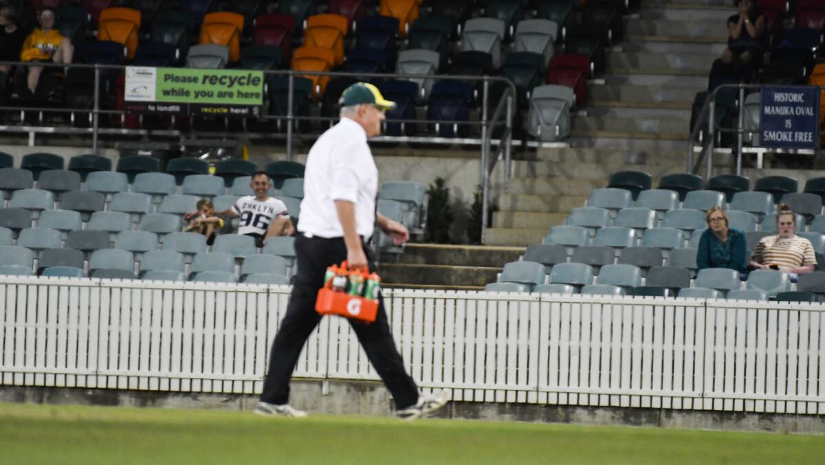 Prime Minister Scott Morrison runs onto the field to give water to the players. Picture: Dion Georgopoulos