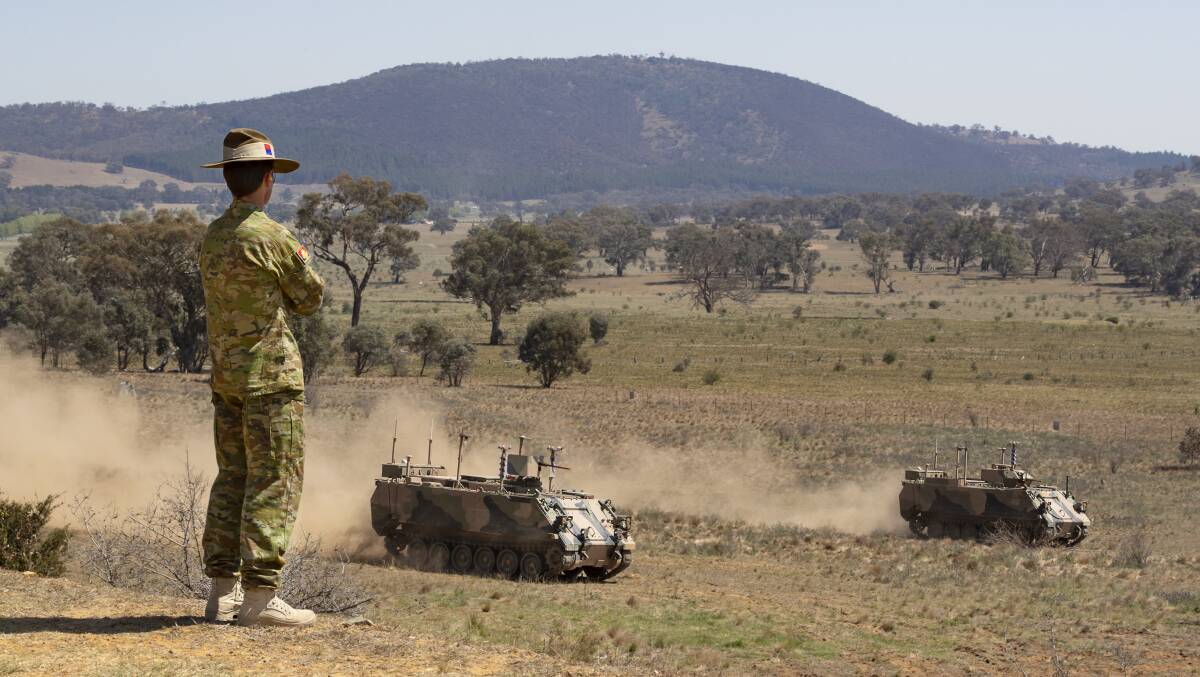 Australian Army officer Brigadier Ian Langford watches on as two autonomous M113 AS4 optionally crewed combat vehicle (OCCV) assault an enemy position at the Majura Training Area, Canberra. Picture: Department of Defence
