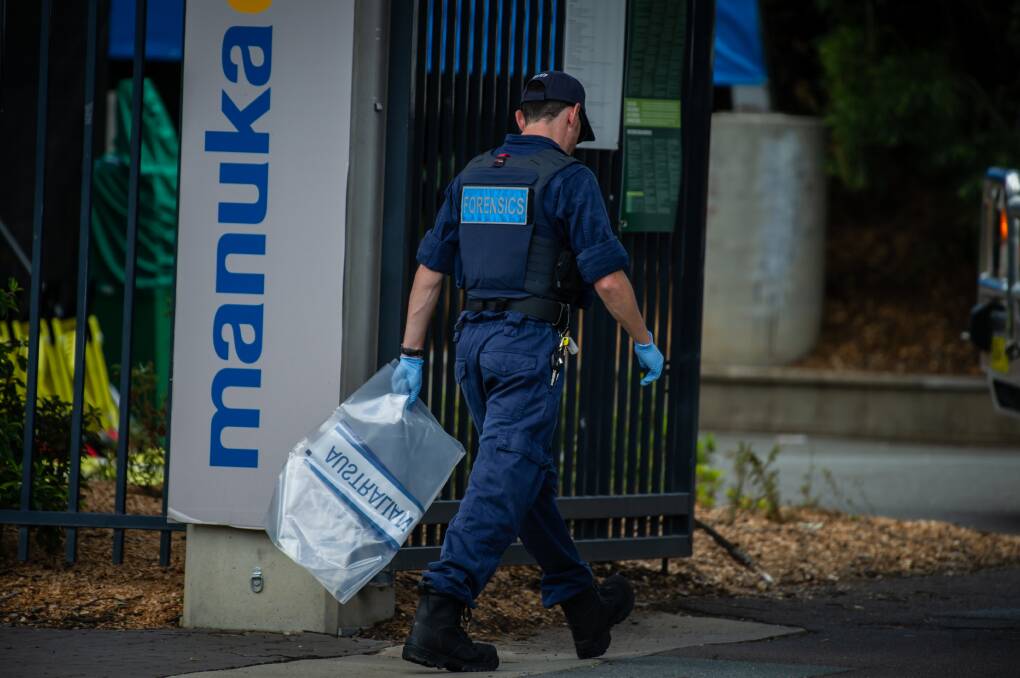 An ACT crime scene investigator taking a bag containing exhibits during an incident at Manuka last year. Picture: Karleen Minney