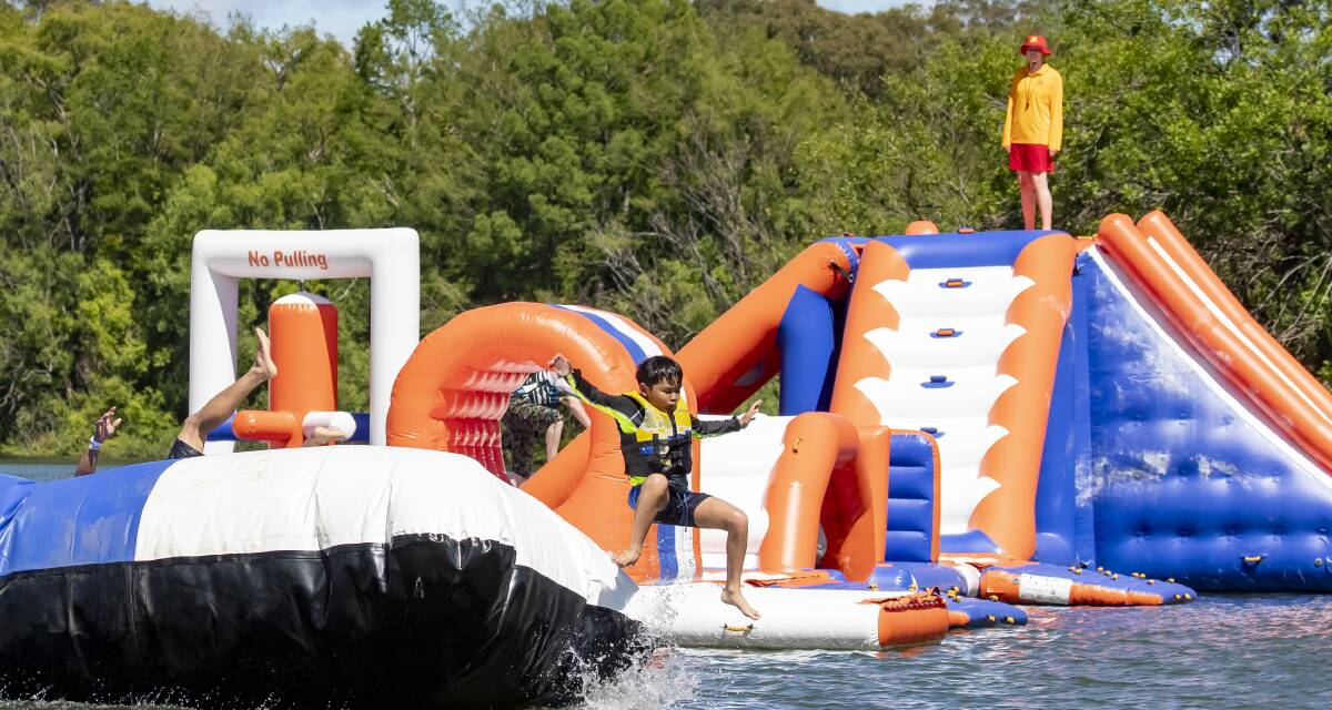 Janssen Villas, 9, gets launched off the pillow at Canberra Aqua Park by his dad, Arnold, on the new attraction's opening morning on Saturday. Picture: Sitthixay Ditthavong