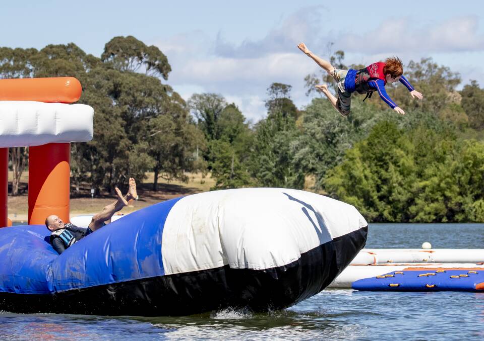 Nick Fejer from Lyneham launches his son Sammy off the giant pillow at Canberra Aqua Park last year. Picture: Sitthixay Ditthavong