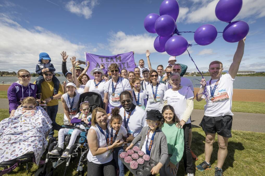 Surrounded by supporters, Mary and Siseho Lishomwa (pictured front) used The Canberra Times Fun Run as an opportunity to raise awareness for Rett syndrome, which their four-year-old daughter Abigail (pictured centre) was diagnosed with. Picture: Sitthixay Ditthavong